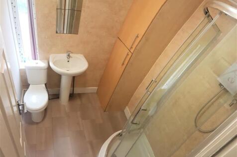 Bright, modern bathroom with a corner shower en...