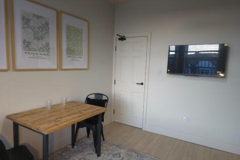 Bright, simply furnished living area with a wal...