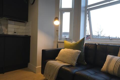 Cosy living area with a dark leather sofa dress...