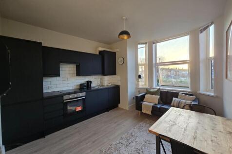 Bright open-plan living area with modern fitted...