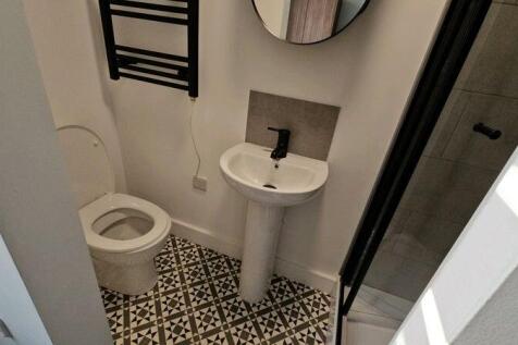 Compact modern bathroom with patterned tile flo...