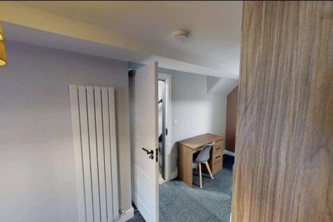 Bright, neatly furnished bedroom with neutral d...