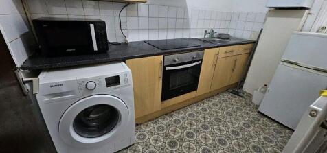 Compact galley kitchen with matching wood-effec...