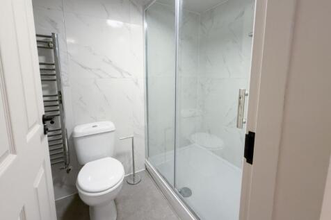Bright, modern bathroom with a large glass-encl...