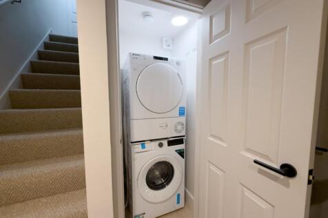 Neat built-in utility cupboard with stacked was...