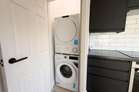 Compact modern kitchenette with integrated stac...