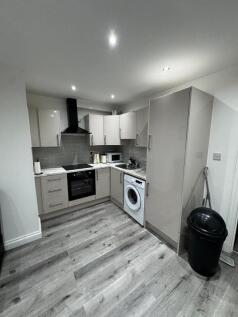 Modern fitted kitchen with integrated oven, hob...