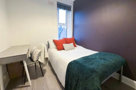 Cozy, neatly styled single bedroom with a comfo...