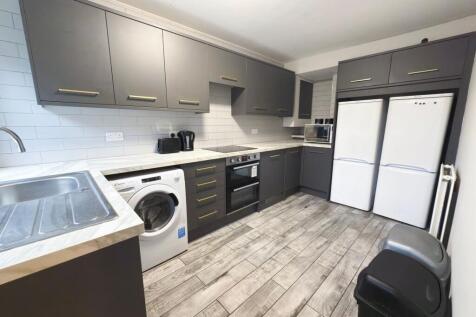 Modern fitted kitchen with dark matte cabinets,...