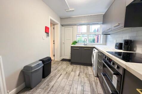 Bright, modern kitchen with grey shaker cabinet...