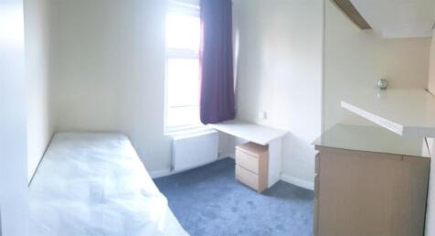 Bright, simply furnished bedroom with a single ...