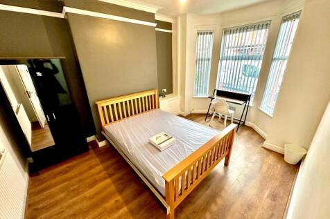 Bright, well-kept double bedroom with a wooden ...