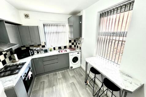 Bright modern kitchen with grey fitted cabinets...