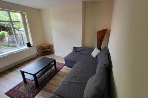 A bright and tidy living room featuring a large...