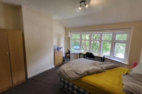 A bright double bedroom featuring a large bay w...