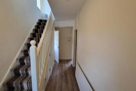 A clean and well-maintained hallway featuring a...