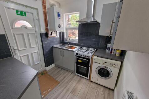 A compact, modern kitchen featuring clean count...
