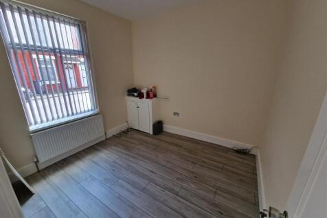 A clean, simple single bedroom featuring a larg...