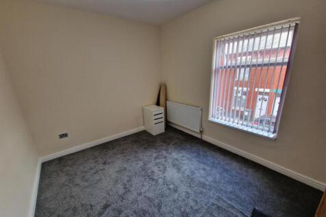 A small and clean room with carpeted flooring, ...