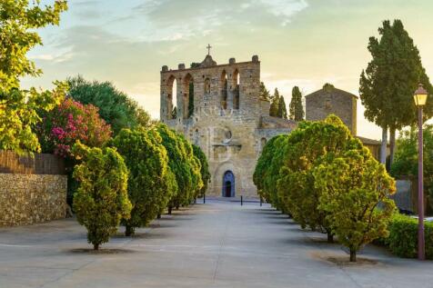 Old stone church with walk with trees at sunset in