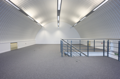 The mezzanine level of an arch, with carpet and lined white.