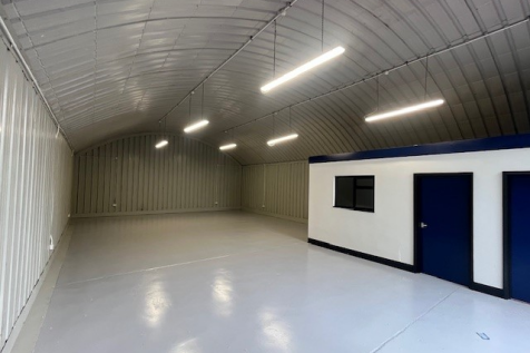An empty arch with white lining and a WC cubicle to the front.
