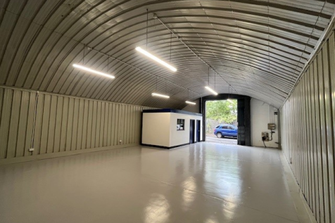 An empty arch with white lining and a WC cubicle to the front.