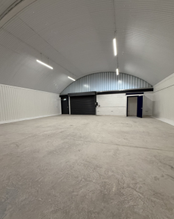 An empty arch with white lining and a WC cubicle to the back.