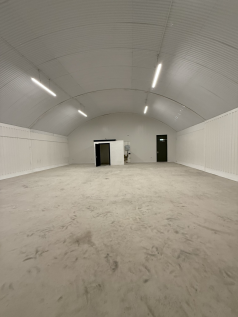 An empty arch with white lining and a WC cubicle to the back.