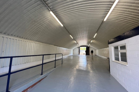 An empty arch with white lining and a WC cubicle to the front.