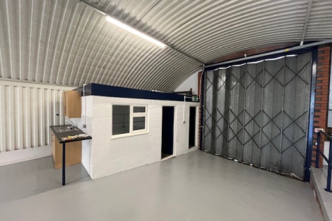 An empty arch with white lining and a WC cubicle to the front.