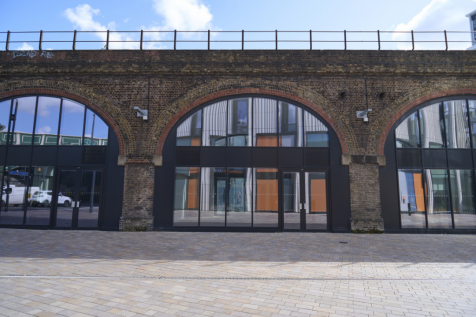 The front of an arch, with a fully glazed frontage and door allowing you to see into the arch interior.