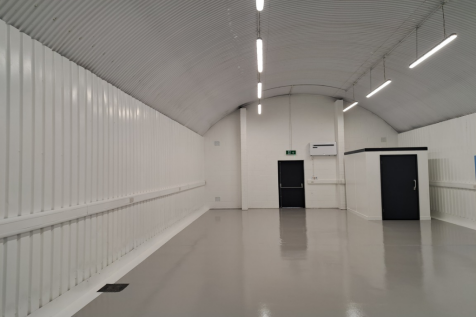An empty arch with lining and a WC cubicle to the back