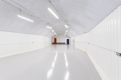An empty arch with white lining and a WC cubicle to the back.