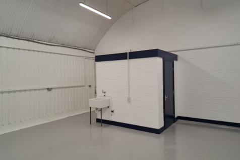 An empty arch with lining and a WC cubicle to the back