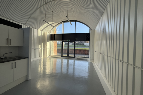 An empty arch with lining and full height glazing to the front