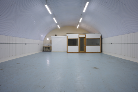 An empty arch with lining, and an office unit at the back.