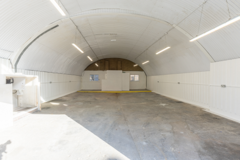 An empty arch with white lining and a WC cubicle to the back.