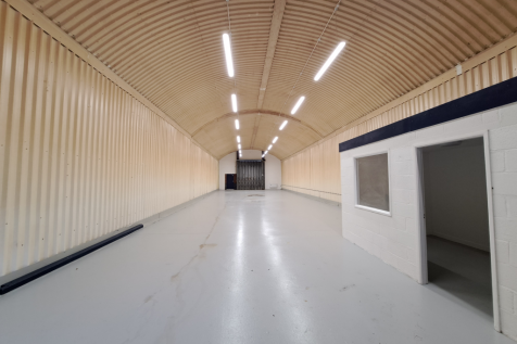 An empty arch with white lining and a WC cubicle to the front.