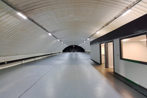 An empty arch with white lining and a WC cubicle to the front.
