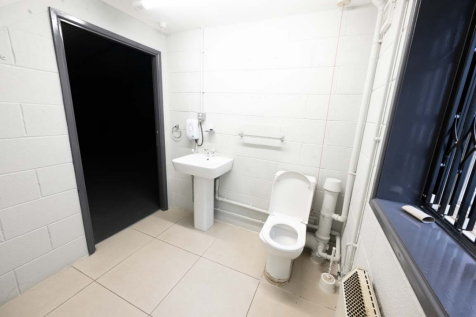 An empty arch with white lining and a WC cubicle to the front.