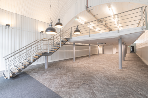 The mezzanine level of an arch, with carpet and lined white.