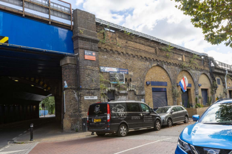 An estate, with multiple arches next to each other. The arches have closed electric roller shutter entrances.