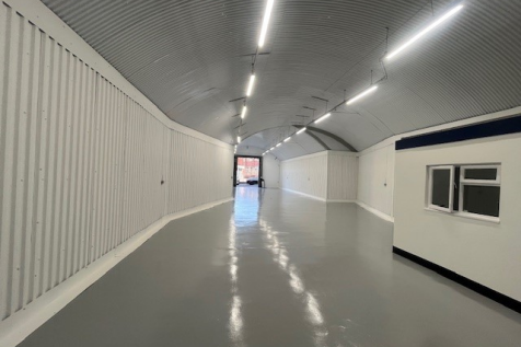 An empty arch with white lining and a WC cubicle to the front.