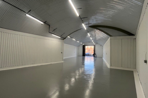 An empty arch with white lining and a WC cubicle to the front.