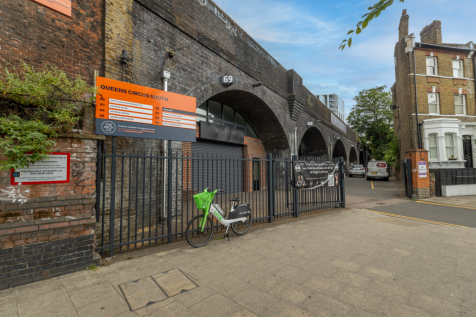 An estate, with multiple arches next to each other. The arches have closed electric roller shutter entrances.