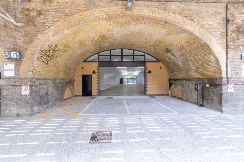 The front of an arch with an open electric roller shutter entrance big enough for vehicle access, and separate pedestrian door.