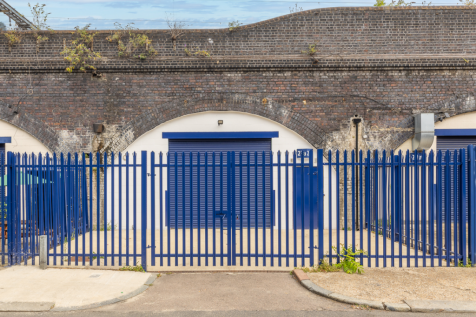 The front of an arch with a closed electric roller shutter entrance big enough for vehicle access.