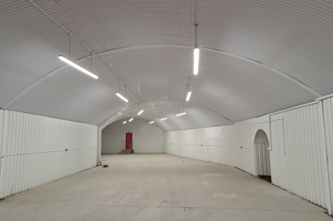 An empty arch with white lining and a fire escape door at the back.