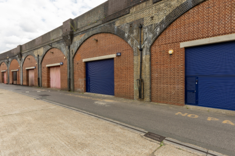 An estate, with multiple arches next to each other. The arches have closed electric roller shutter entrances.